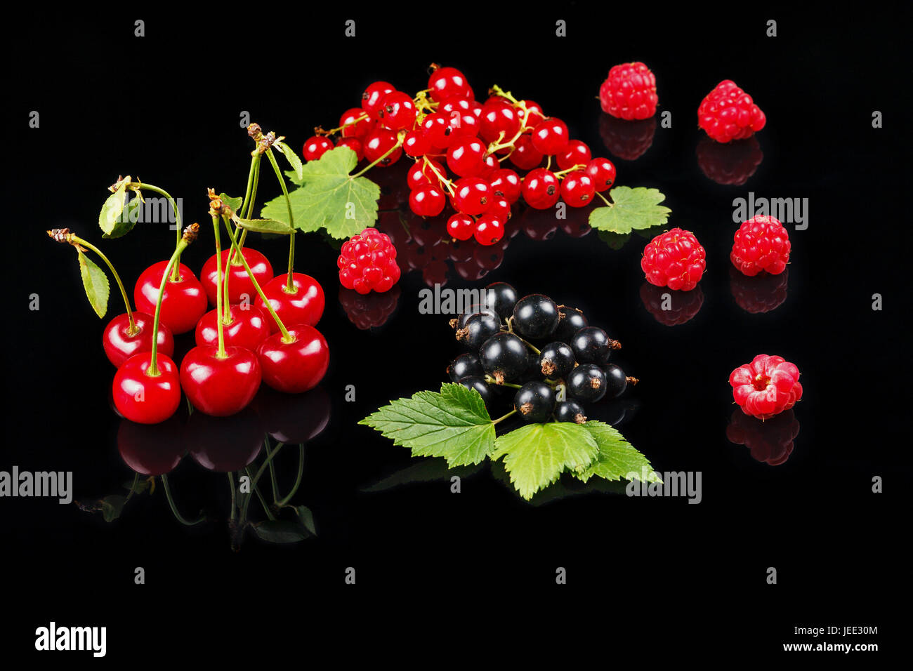 Fruits of cherry, raspberry, black currant and red currant on a dark background. Close-up Stock Photo