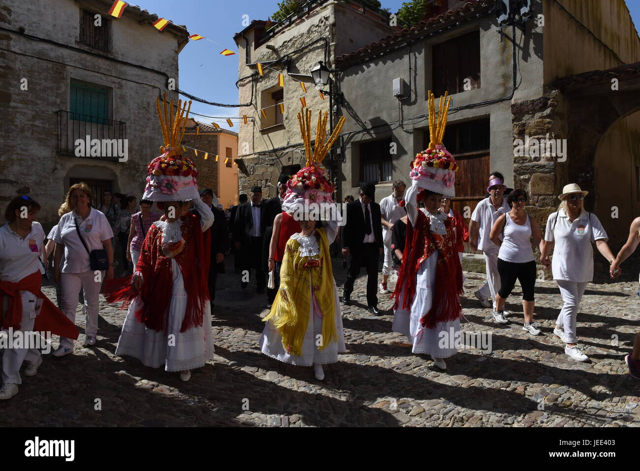 San Pedro Manrique, Spain. 24th June, 2017. A group of women called 'Móndidas' dressed in traditional costumes and wearing huge 'Cestaños', hats decorated with flowers and branches, covered with unleavened bread and colored with saffron, pictured during the celebration of the ancient tradition of 'La Descubierta' in San Pedro Manrique, northern Spain. Credit: Jorge Sanz/Pacific Press/Alamy Live News Stock Photo