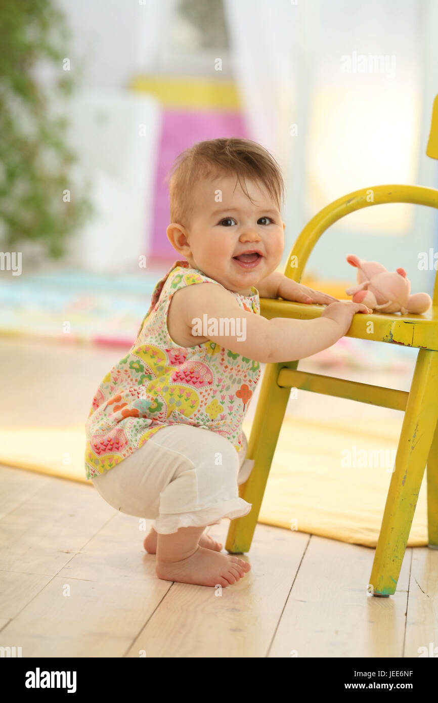 Baby, 10 months, get up, hold on chair, summer, Stock Photo