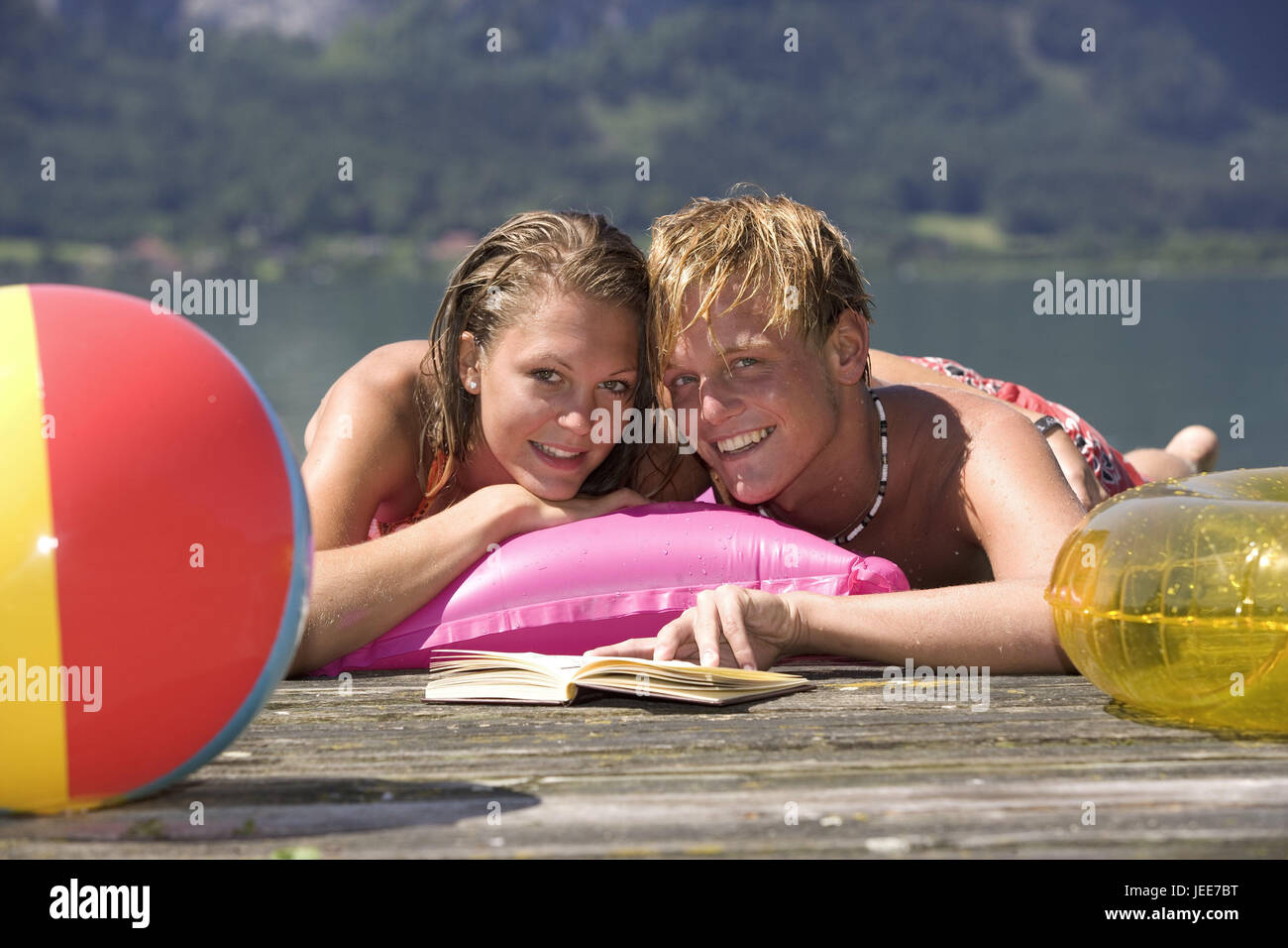 Lakes, bridge, teenager's couple, smile, lie, read book, portrait, person, youth, teenager, young persons, couple, love, affection, holidays, leisure time, summer, beach-ball, ball, pneumatically, touch, holiday flirtation, air bed, happily, falls in love, sun themselves, détente, Stock Photo