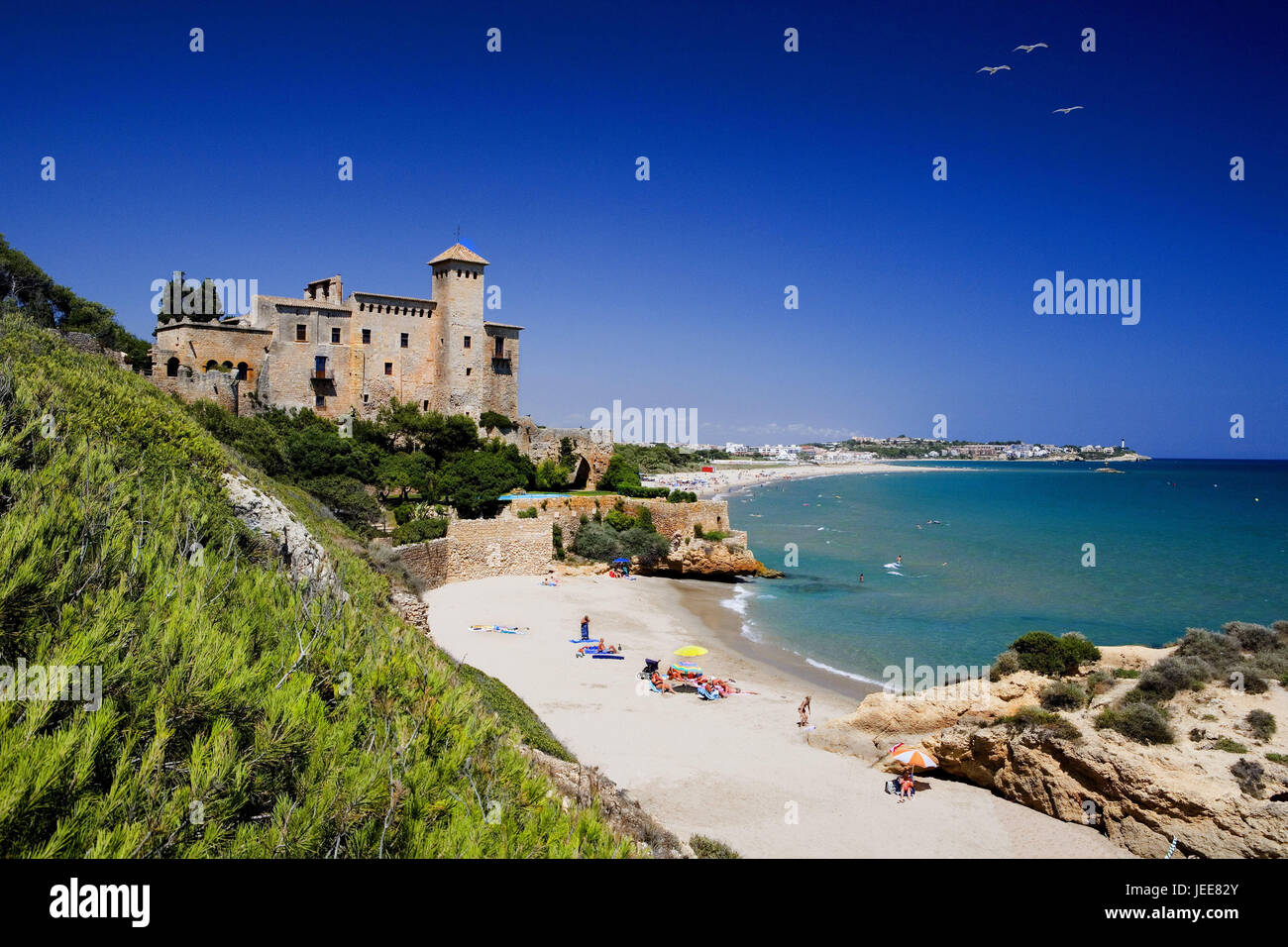 Spain, Catalonia, Tamarit, Castillo de Tamarit, the Mediterranean Sea, coastal region, bile coast, bath bay, beach, sandy beach, bathers, tourists, people, solar bath, lock, lock building, structure, architecture, place of interest, destination, tourism, vacation, summer vacation, beach holiday, Stock Photo