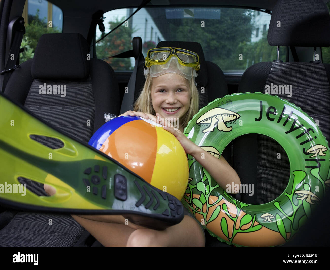 Passenger car, ground, girl, bath implements, sit, people, children, childhood, blond, long-haired, happily, diver's glasses, fins, beach-ball, swimming tyre, pneumatically, holidays, vacation, leisure time, holiday trip, beach holiday, prejoy, joy, fun, swimming things, car, sit, Stock Photo