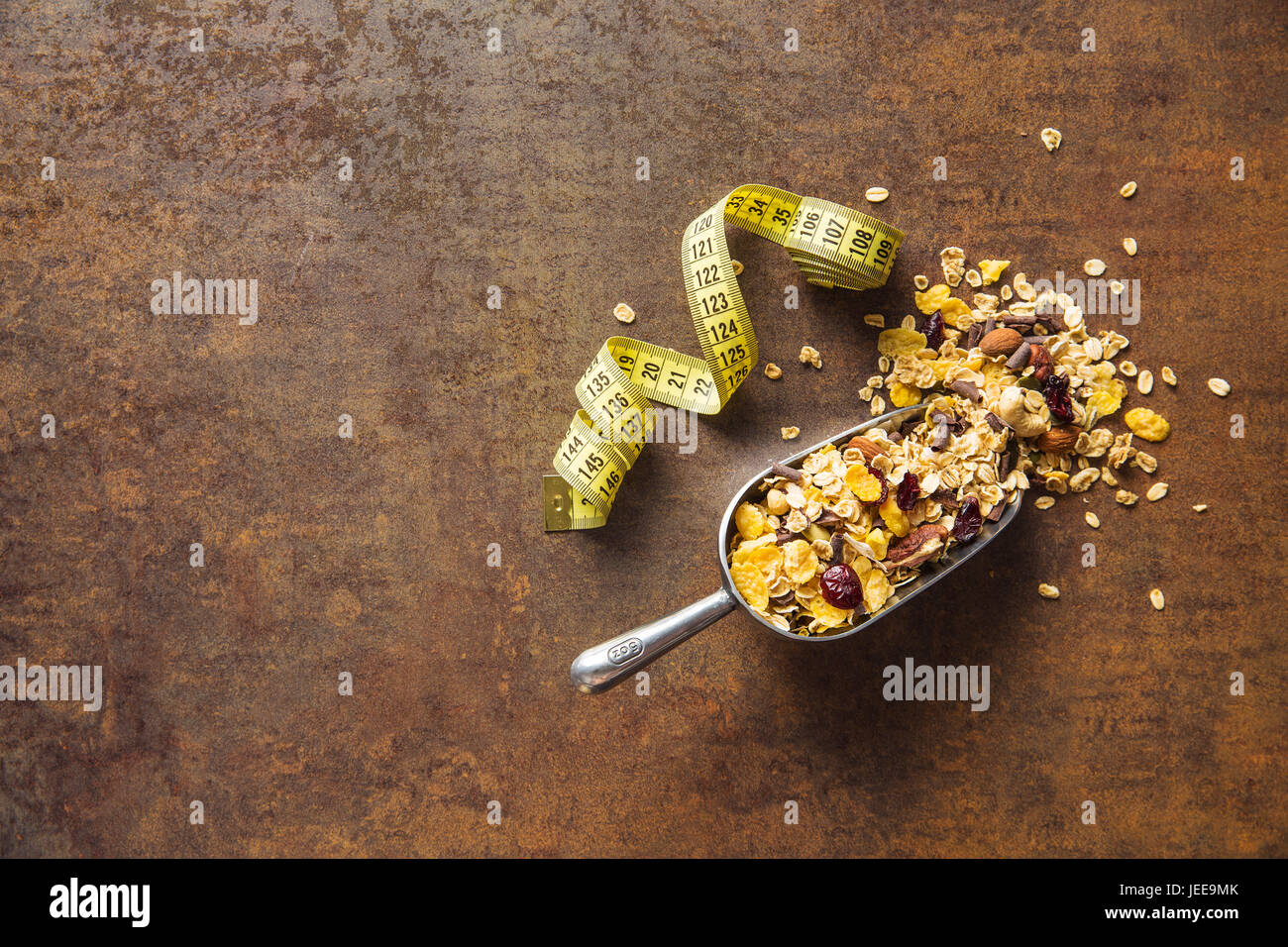 Tasty homemade muesli with nuts and measuring tape. Diet concept. Top view. Stock Photo