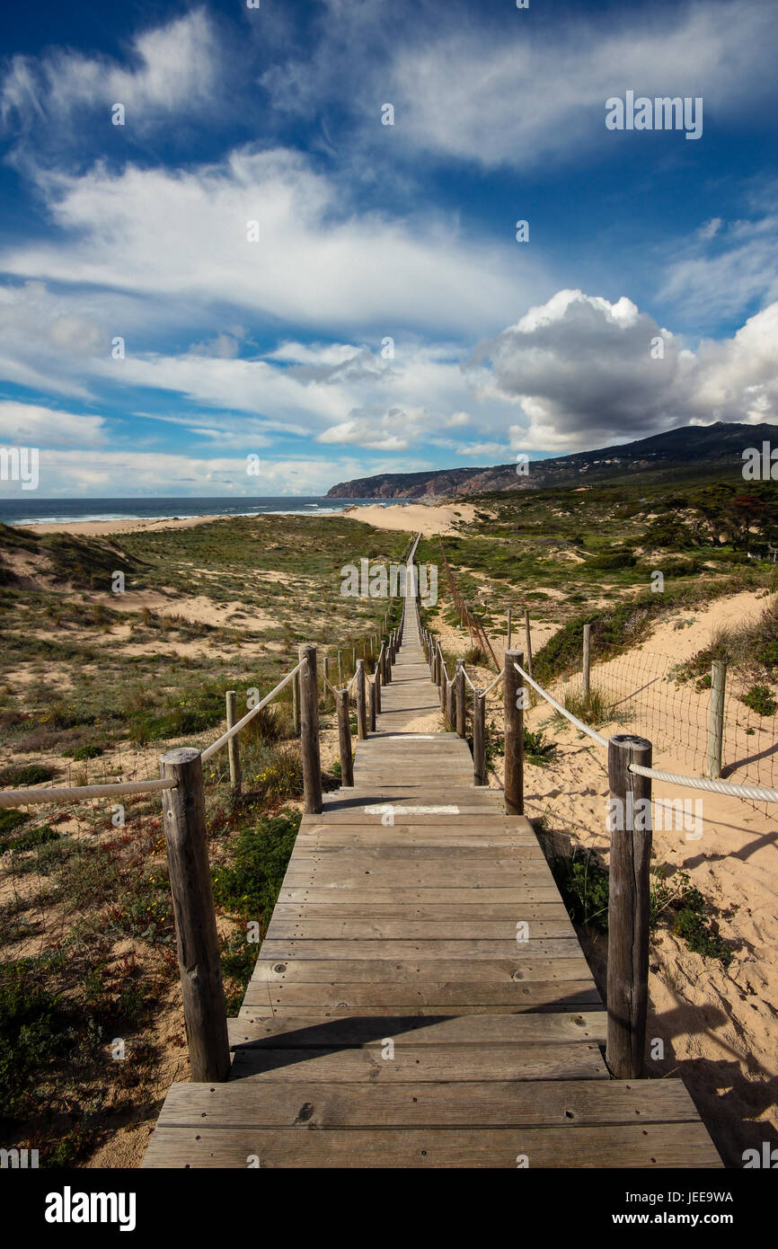 Wooden path to the beach on the dunes. Guincho beach in Cascais, Portugal Stock Photo
