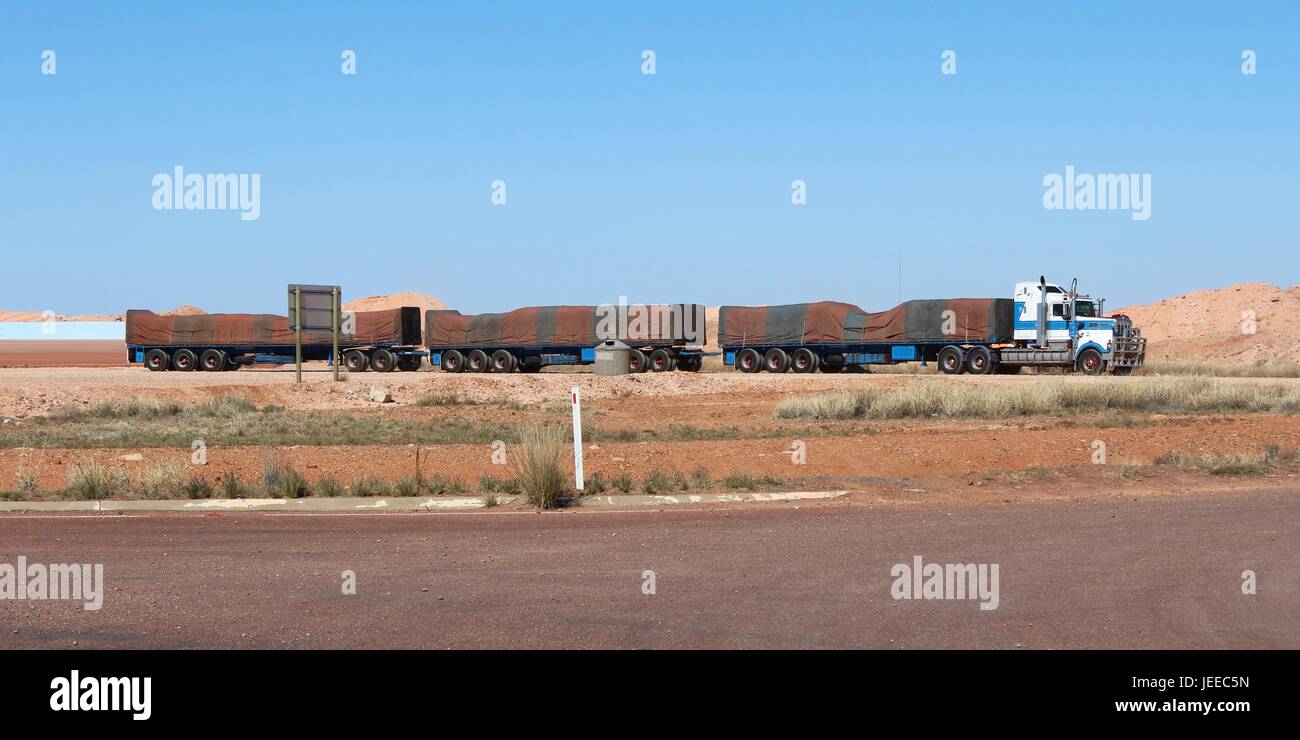 Australian road train with green and brown striped tarpaulin in full-length. Stock Photo
