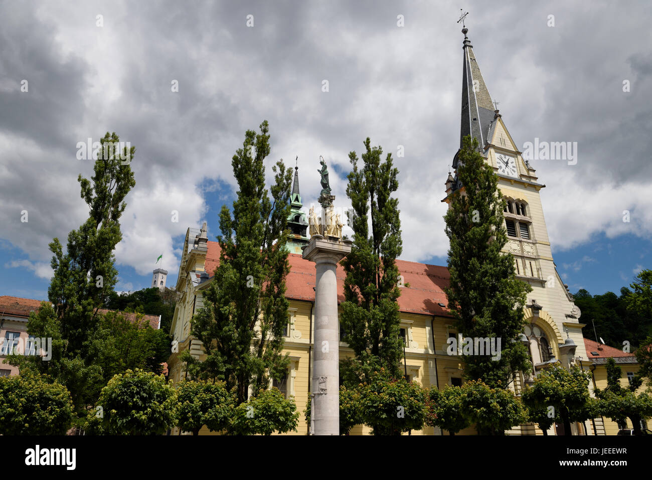 St James parish Catholic church and St. Mary's Column of the virgin in brass and stone statues of saints Ljubljana Slovenia with tower on Castle Hill Stock Photo
