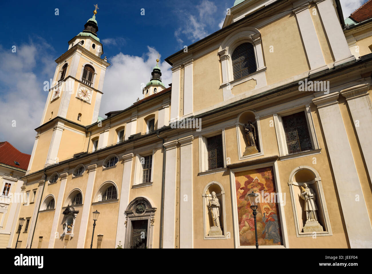 Southern facade of St. Nicholas church Ljubljana Cathedral Slovenia with belfry, frescoe, and statues of saints Joseph, Hermagoras and Fortunatus Stock Photo