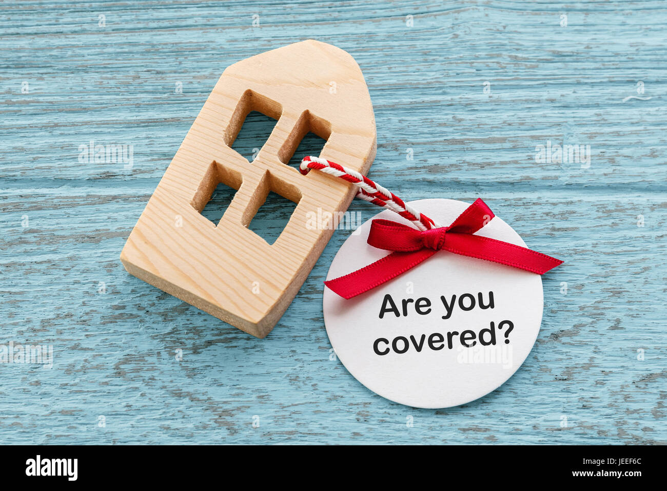 Home insurance concept with wood house and paper  tag Stock Photo