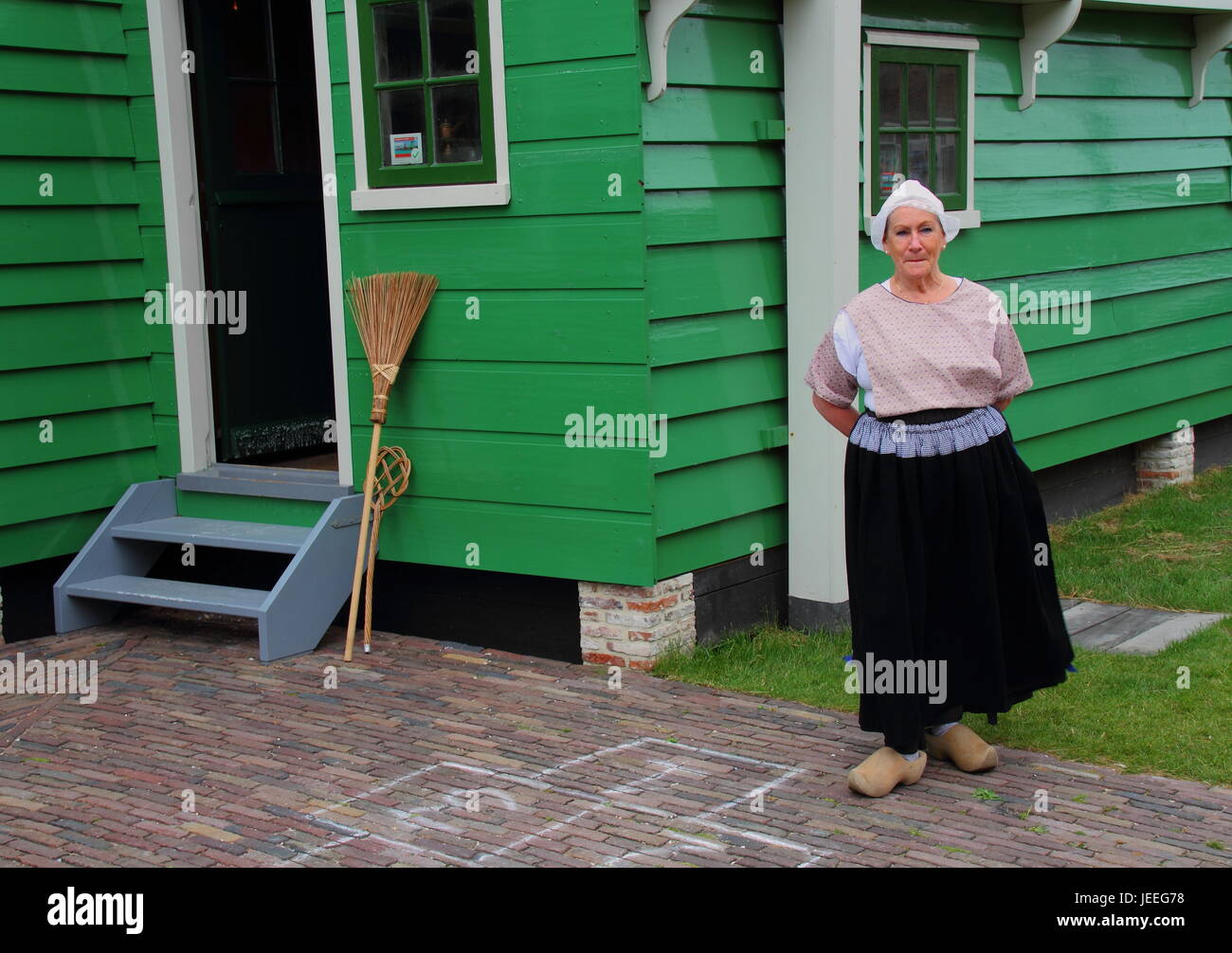 Zaanse Shans Netherlands - unidentified woman in traditional Dutch clothing stands outside her home Stock Photo