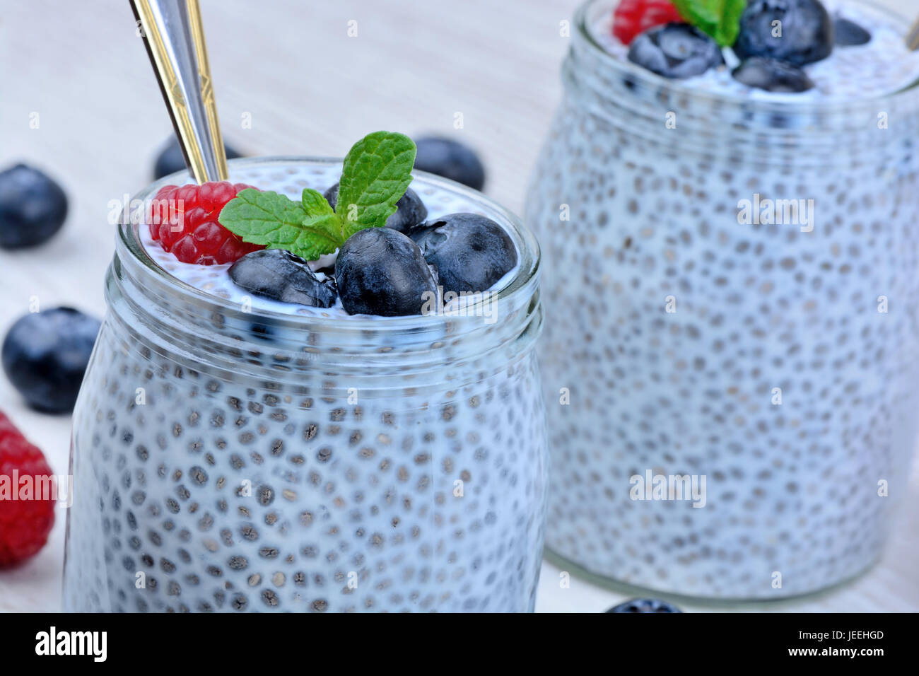 Jar with chia seeds and berries on wooden table close-up Stock Photo