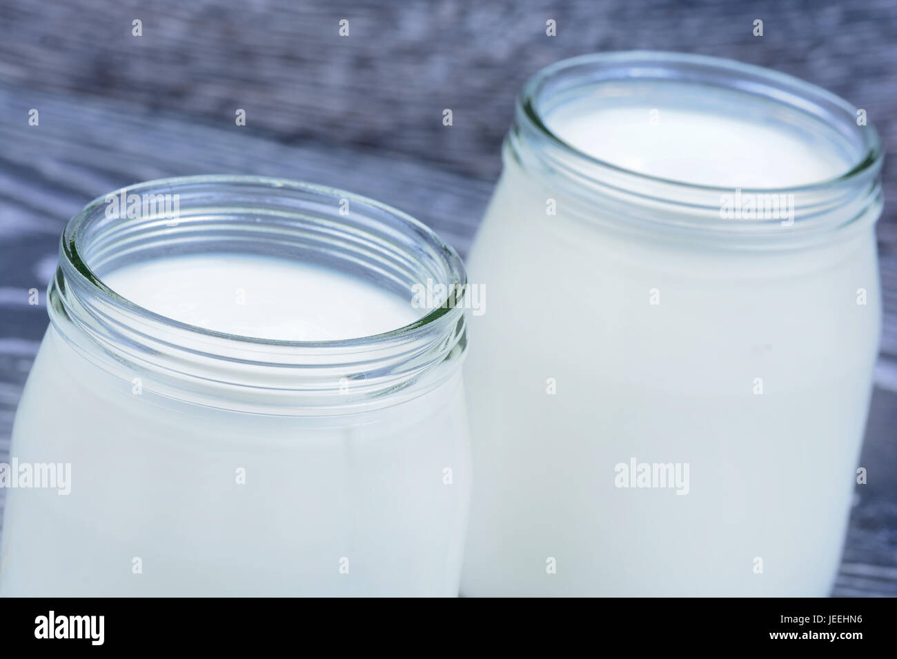 Yogurt in a jars glass on wooden table Stock Photo