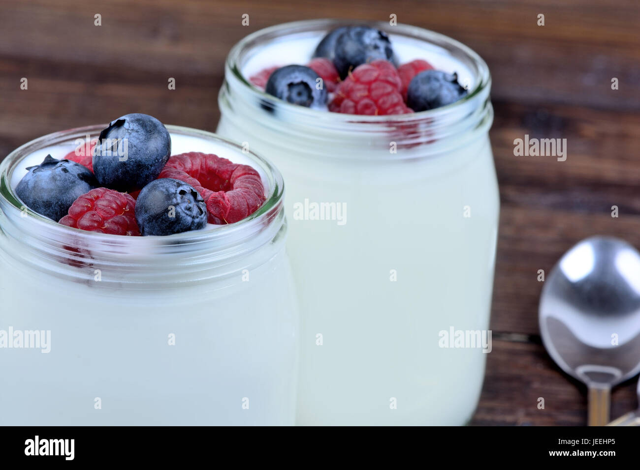 Assorted berries with yogurt in a glass on table Stock Photo