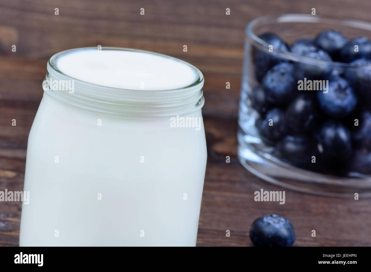 Yogurt with blueberries in a glass on wooden table Stock Photo