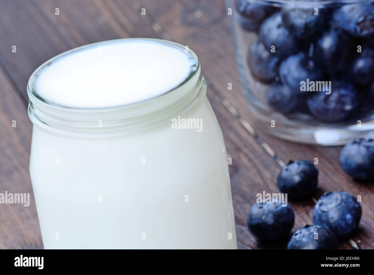 Glass with yogurt and blueberry on wooden table Stock Photo