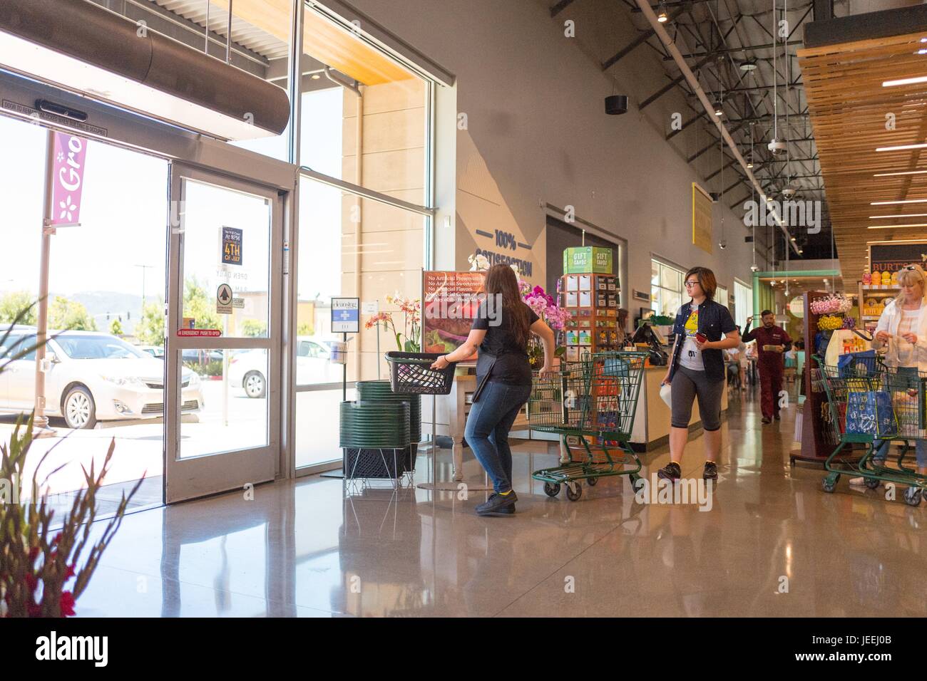Several shoppers push carts towards the exit at the Whole Foods Market grocery store in Dublin, California, June 16, 2017. Stock Photo