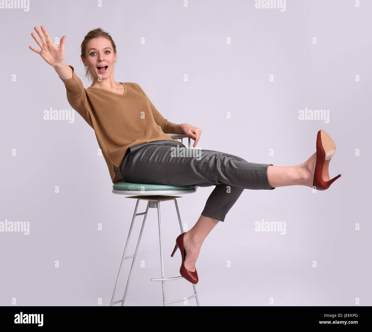 Pretty woman sitting on a chair isolated. Full body Stock Photo