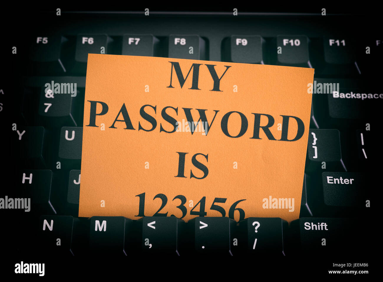 Paper note with easy password on black computer keyboard. Internet security concept. Close up. Stock Photo
