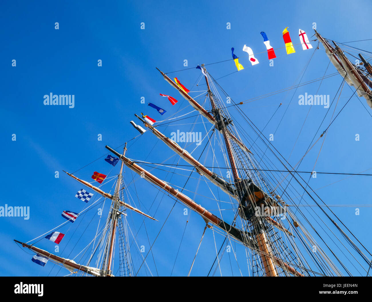 Skyward view of row of pennant flags flying on masts of SSV Oliver Hazard Perry tall ship, Newport, Rhode Island, USA Stock Photo