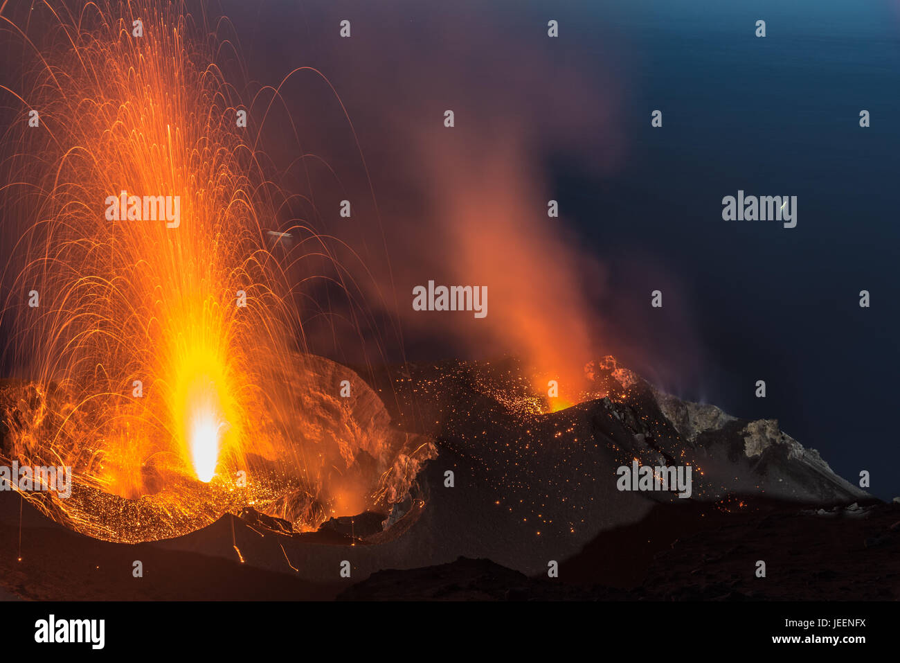 Strong strombolian volcanic eruption from Stromboli volcano (Eolian Islands, Lipari, Italy) at night, craters illuminated by moonlight, June 2017 Stock Photo
