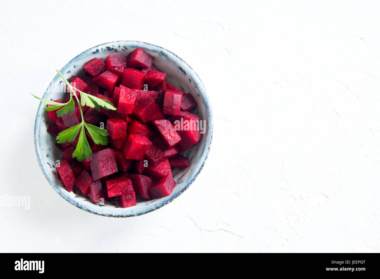 Beetroot (beet) chopped for salad in bowl over white background with copy space. Healthy ingredient for cooking. Stock Photo