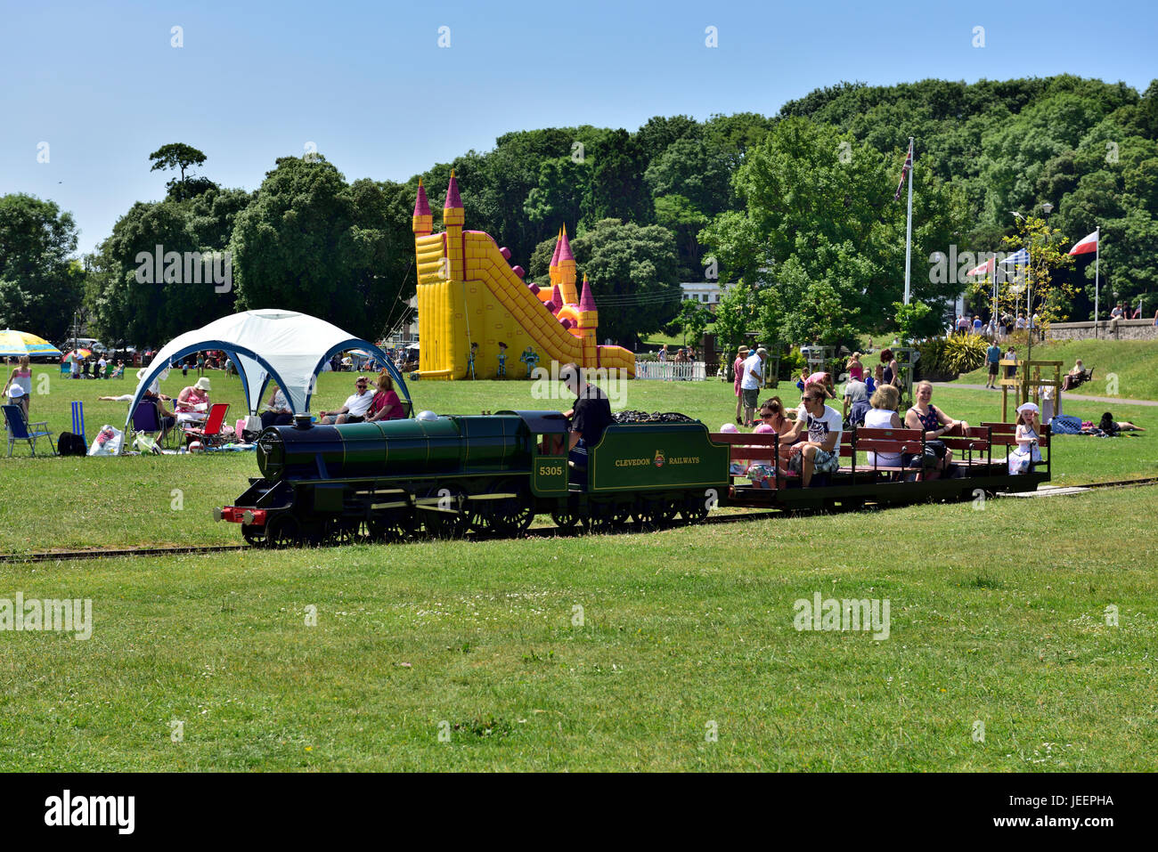 Summer at the seaside visiting Clevedon Salthouse Park, North Somerset, with miniature railway and bouncy castle Stock Photo
