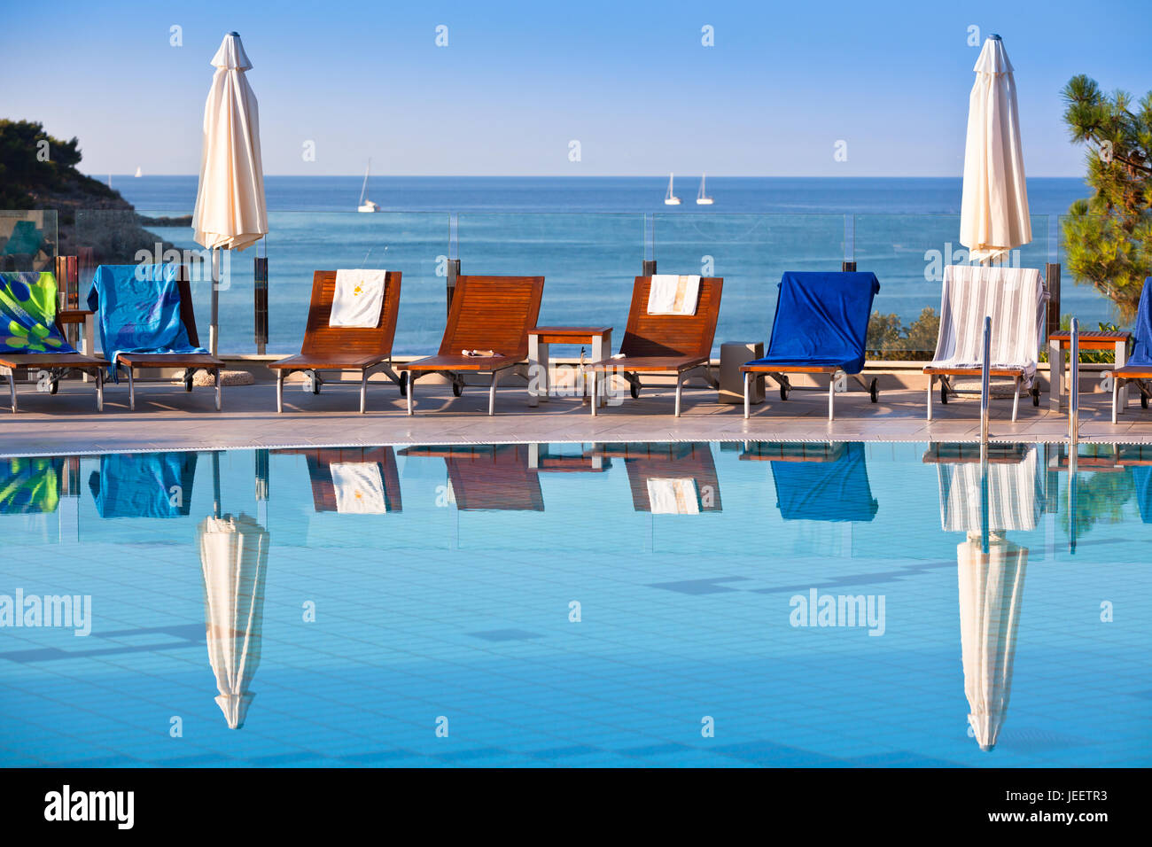 Sunbeds and umbrellas by the swimming pool on a sunny day Stock Photo ...