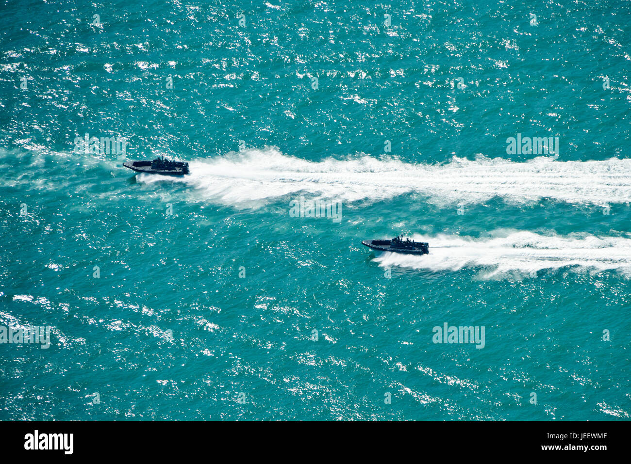Horizontal aerial view of two speedboats of the Marine Police racing across Victoria Harbour in Hong Kong, China. Stock Photo