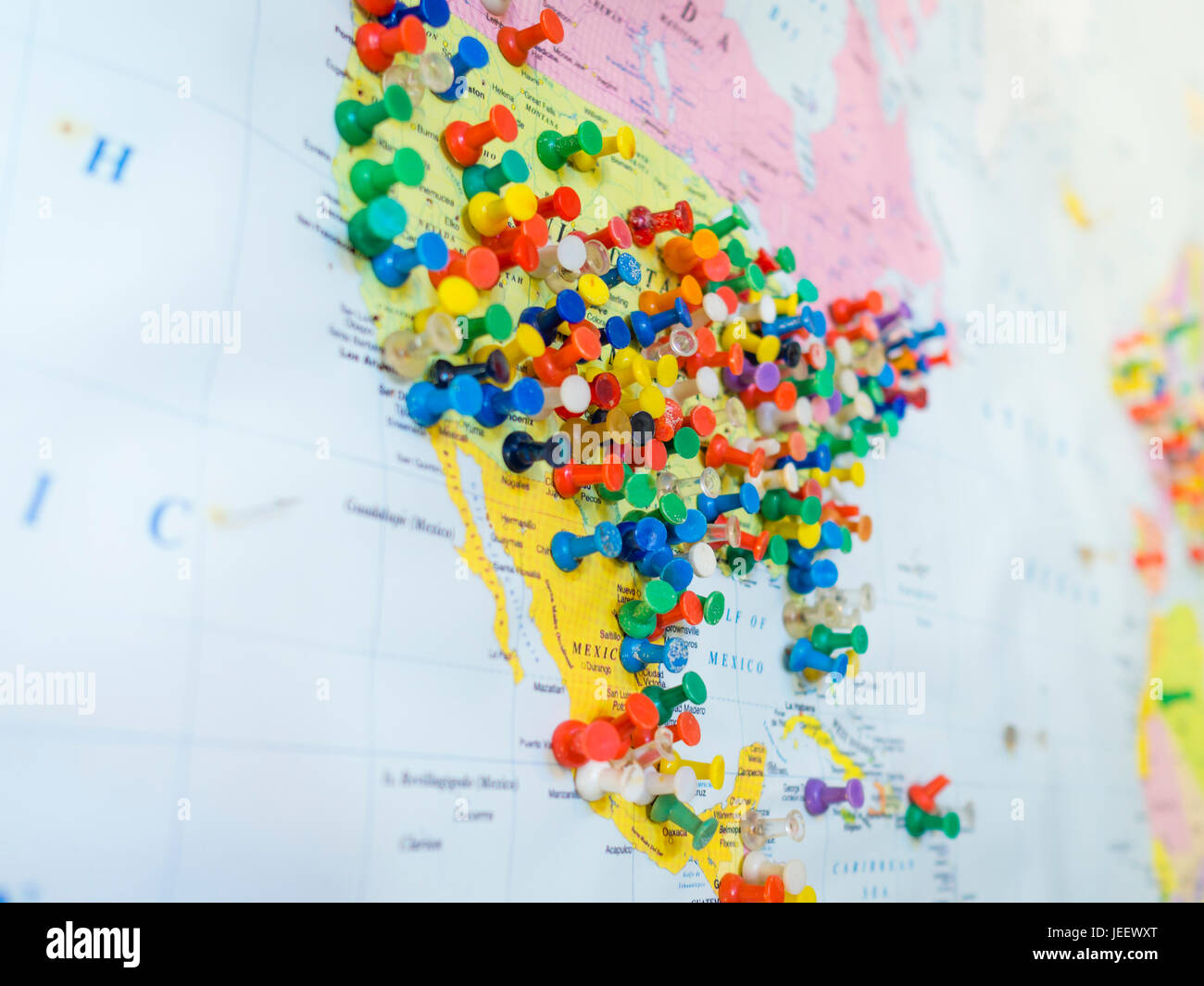 Many colourful pins in a wall map of America. The map is hanging on the ...