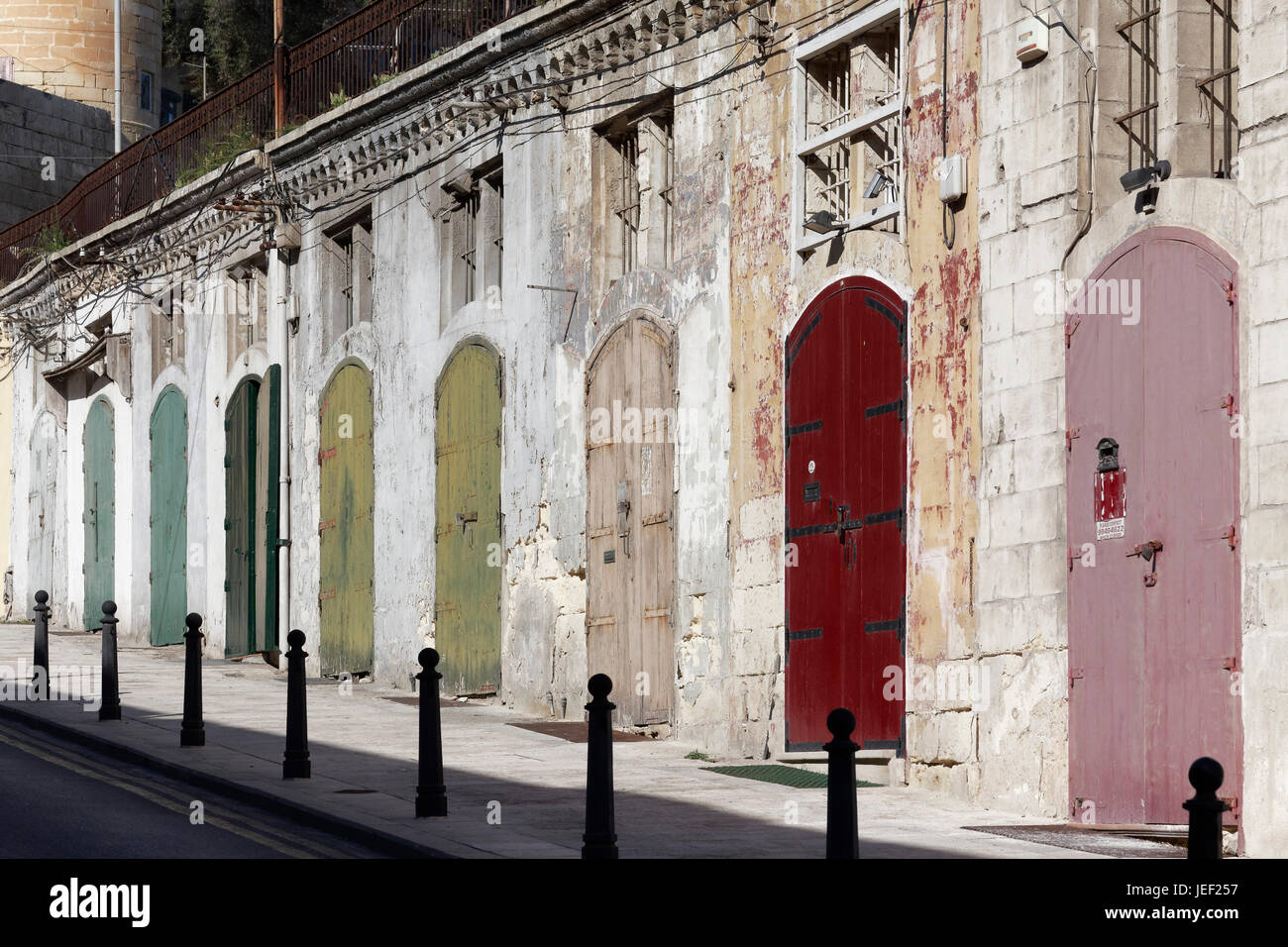 Old warehouse with colorful doors at Barriera Wharf, Liesse Street, Valletta, Malta Stock Photo