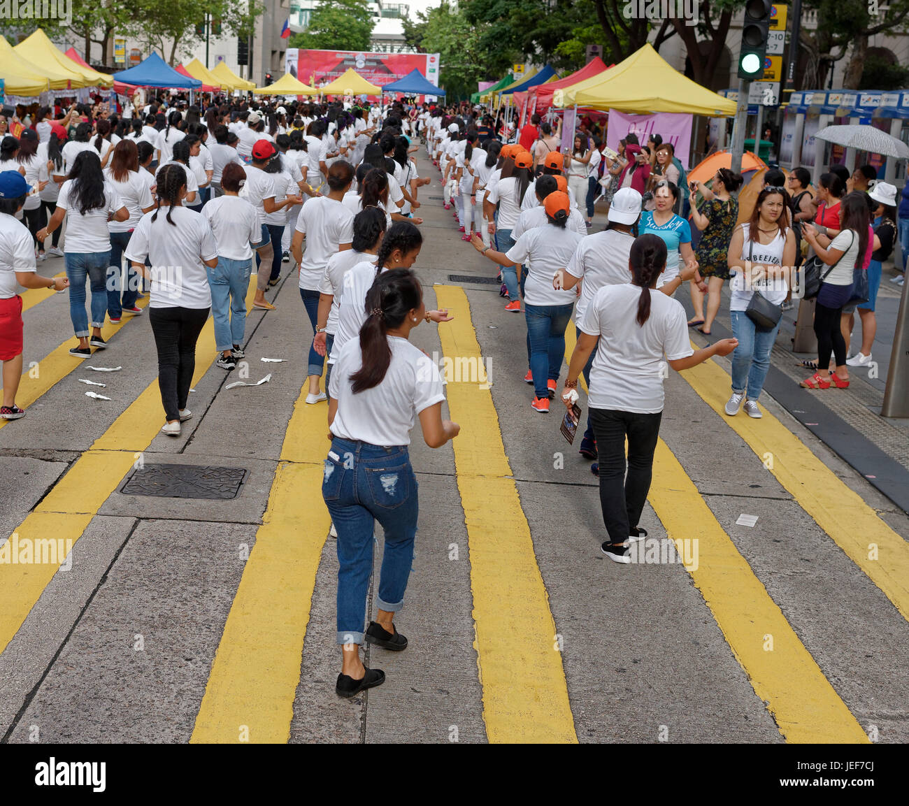 Filipino workers in Hong Kong create a massive line dance on the streets of Central. Stock Photo