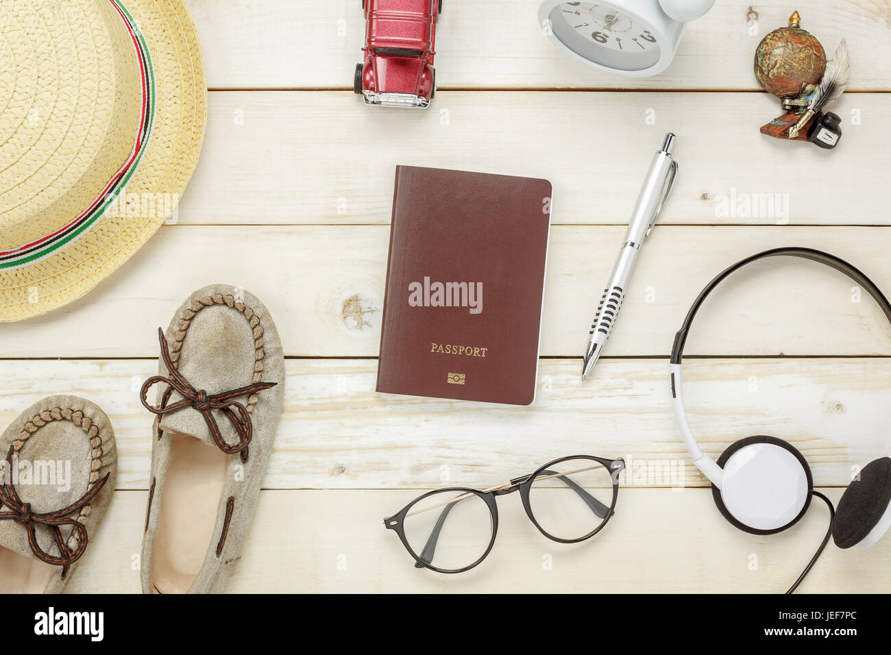 Top view essential travel items.The shoes notebook tree map passport airplane car eyeglasses on rustic  wooden background. Stock Photo