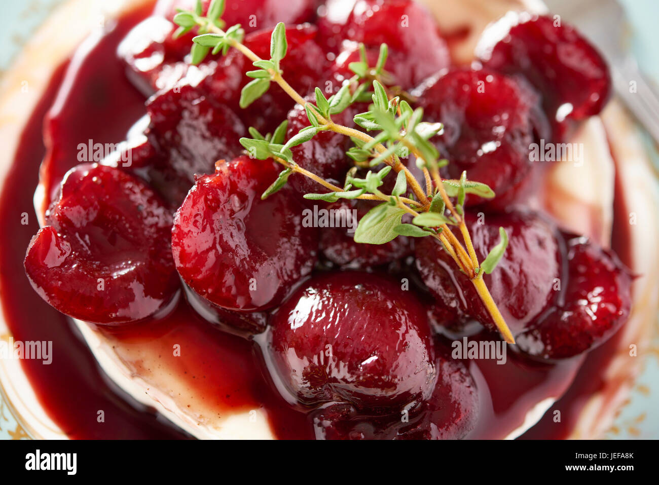 Brie cheese with warm cherry compote served on a blue plate Stock Photo