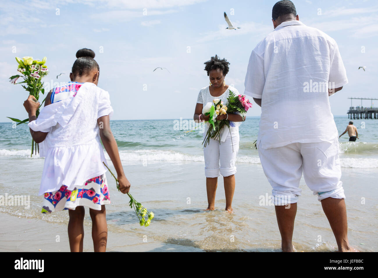 Black color family about to throw flowers to the Ocean in Coney Island