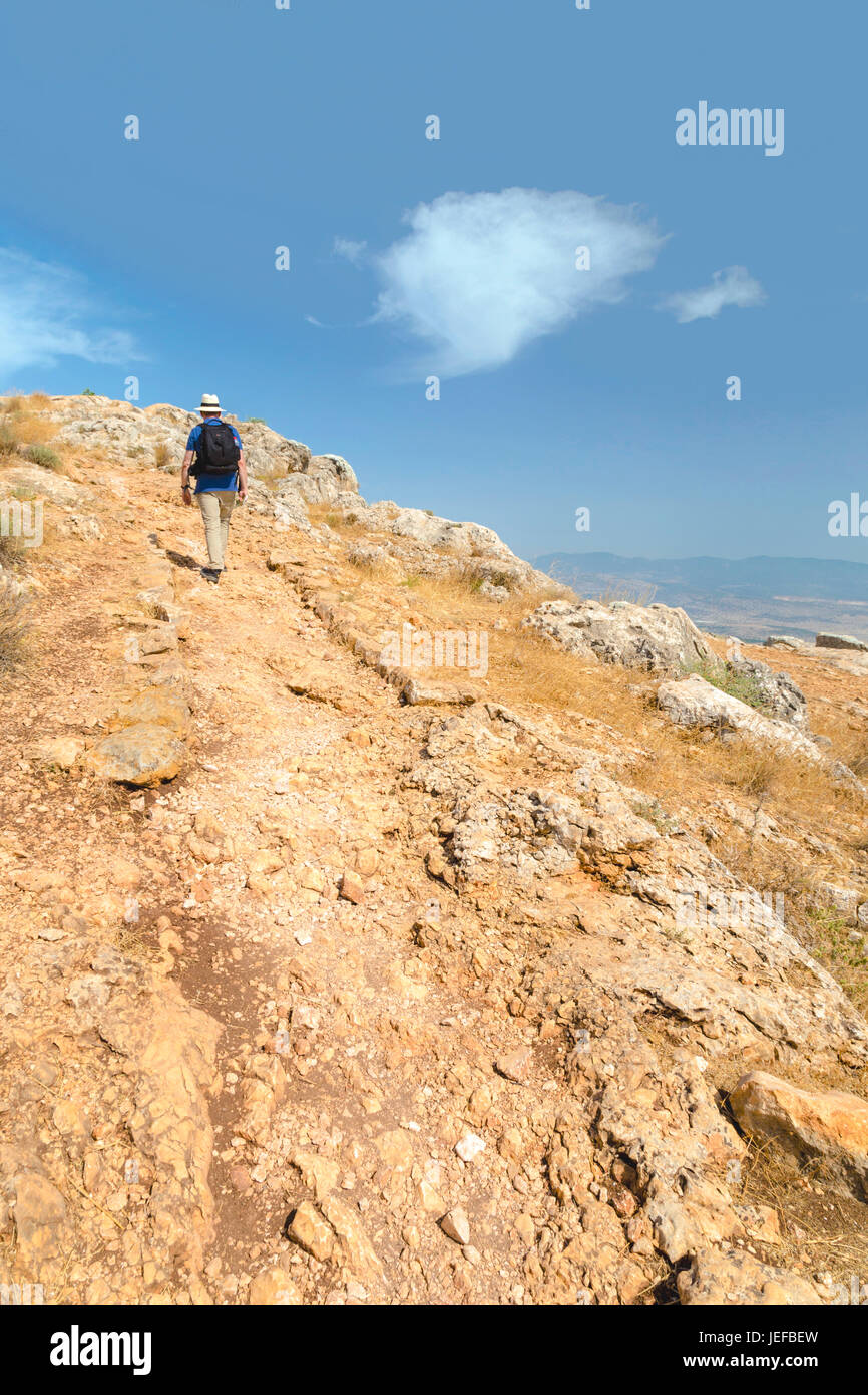 Rear view of a hiker climbing to the summit of Mount Arbel, near the ...