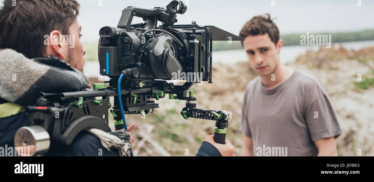 Behind the scene. Actor in front of the camera on the film set outdoor ...
