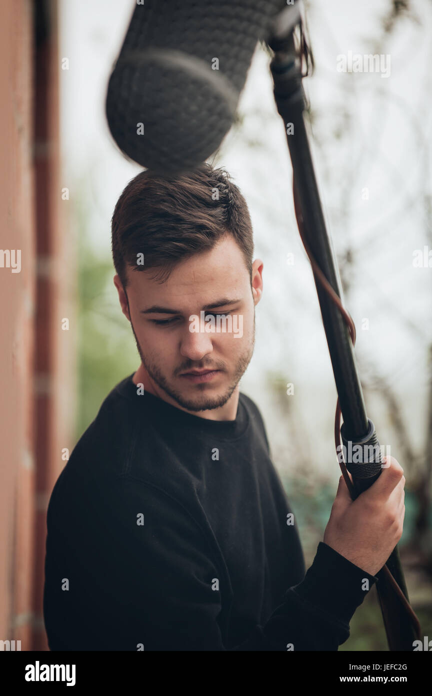 Behind the scene. Sound boom operator hold microphone fisher on outdoor