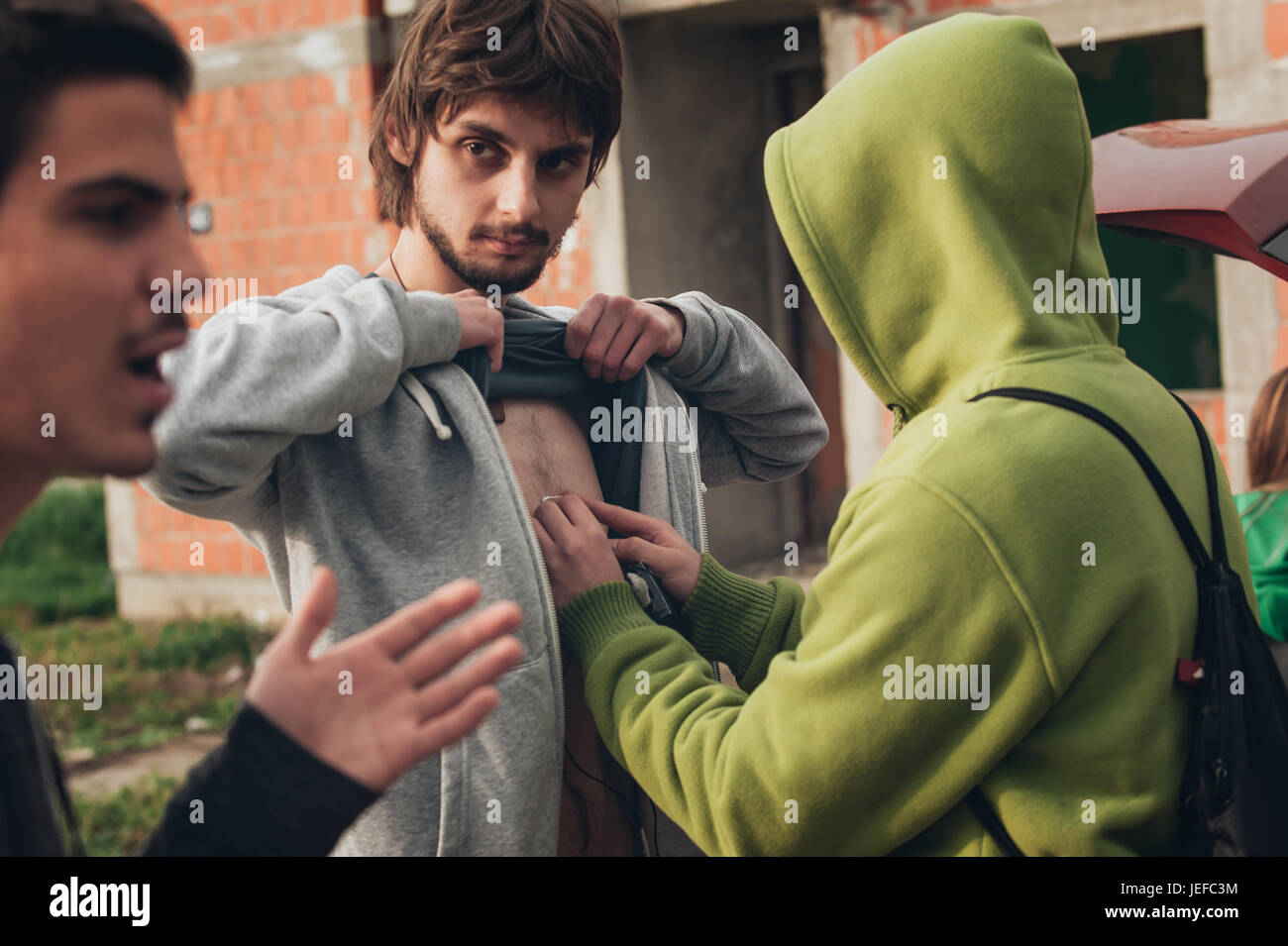 Behind the scene. Sound technician puts the lavalier microphone under actor shirts. Lav mic Stock Photo