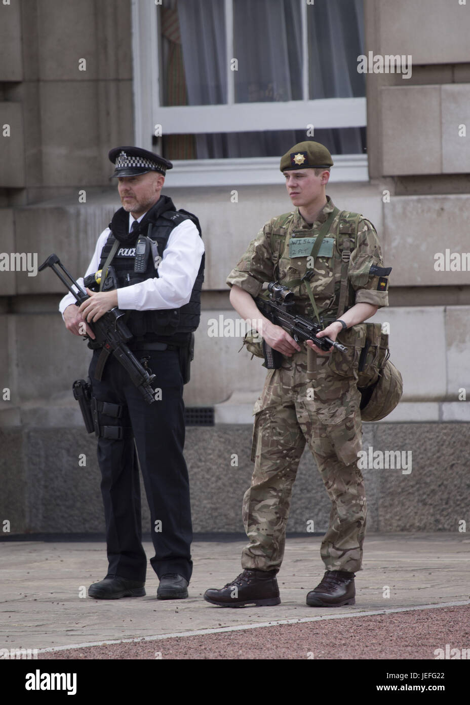 Armed police and military protecting Buckingham Palace. Featuring ...