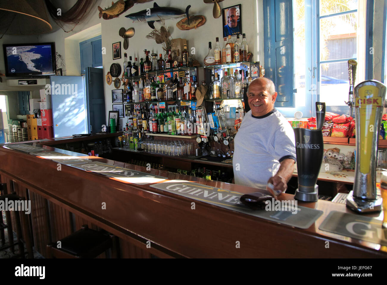 Barman inside Gleneagles Bar pub at Mgarr, Gozo, Malta Stock Photo