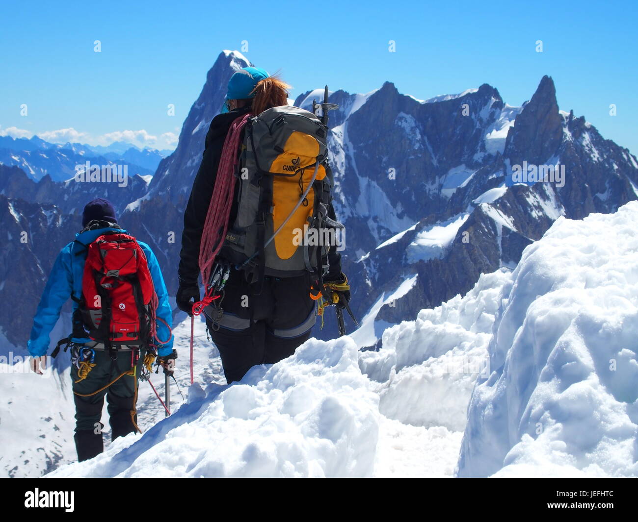 Two alpinists and mountaineer climber on AIGUILLE DU MIDI, CHAMONIX MONT BLANC french ALPS, top alpine mountains range landscape, FRANCE on July. Stock Photo