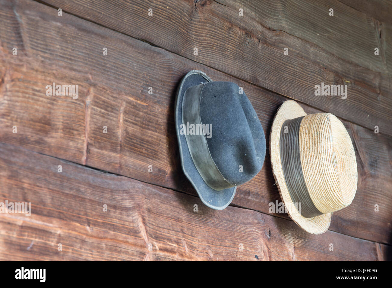 two hats hanging in a wooden wall Stock Photo