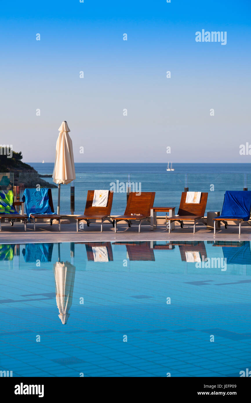 Sunbeds and umbrellas by the swimming pool on a sunny day Stock Photo ...