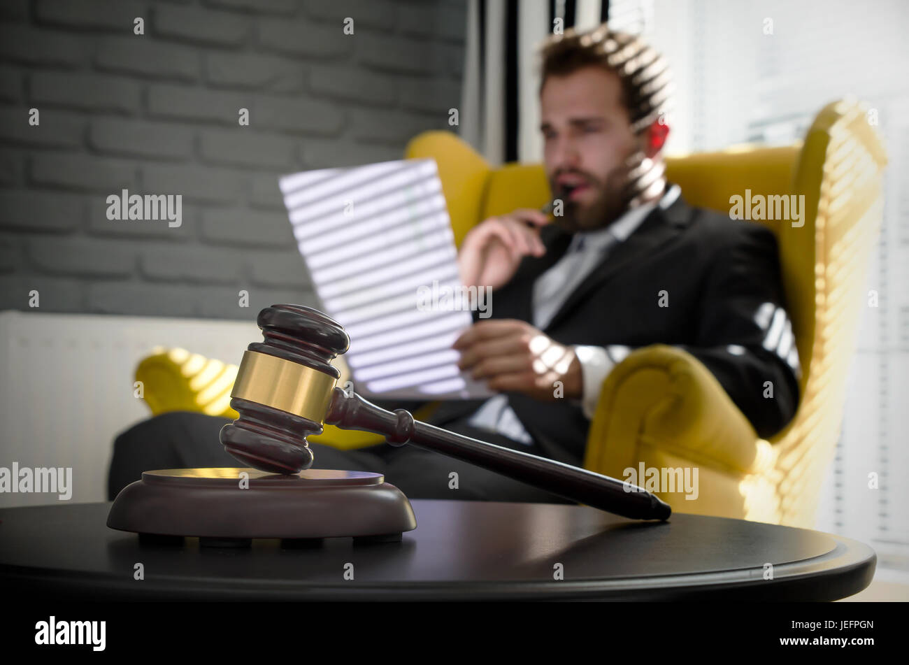 Wooden gavel, working lawyer in background. attorney business judgment justice suite analyzing authority background concept Stock Photo