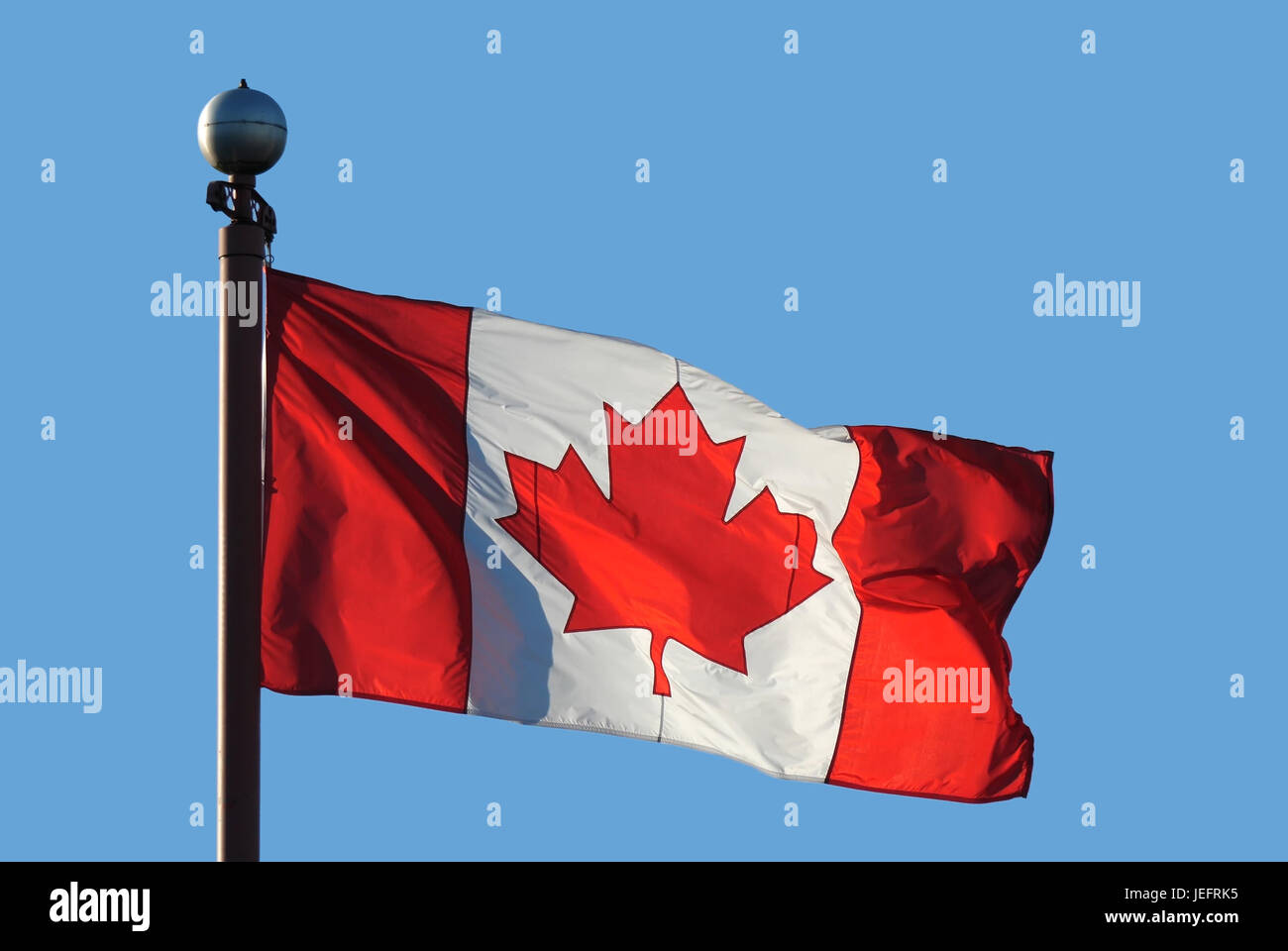 Waving Canadian flag against blue sky for celebrating Canada 150 years Stock Photo