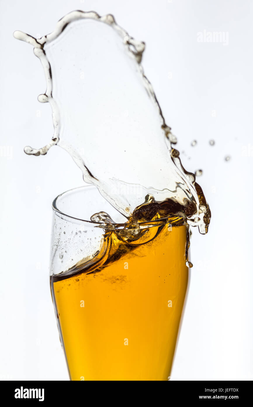 Splashing beer from a glass on white background Stock Photo Alamy
