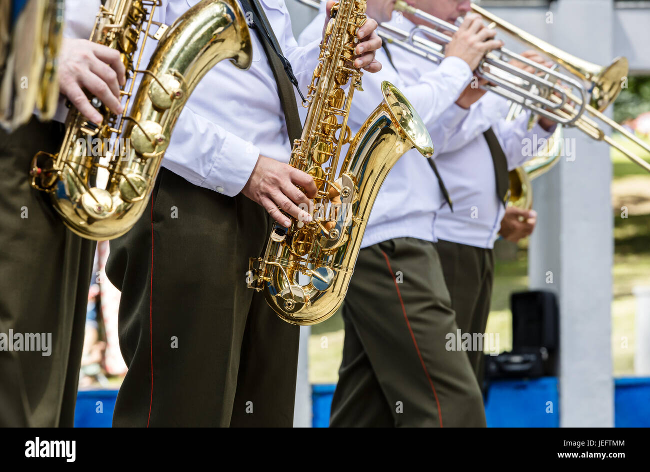 military brass band musicians playing saxophones and trombones during music fest Stock Photo