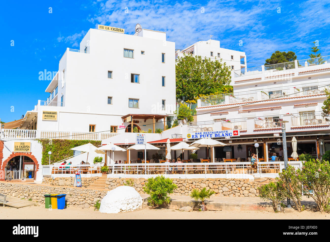 CALA PORTINATX BAY, IBIZA ISLAND - MAY 22, 2017: Hotel and restaurant buildings in Cala Portinatx bay on sunny summer day, Ibiza island, Spain. Stock Photo