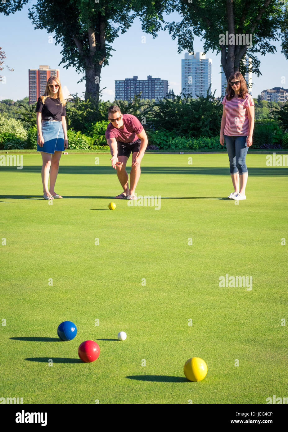Friends play bocce ball on a manicured bowling green at the Royal Lawn Bowling Club in Edmonton, Alberta, Canada. Stock Photo