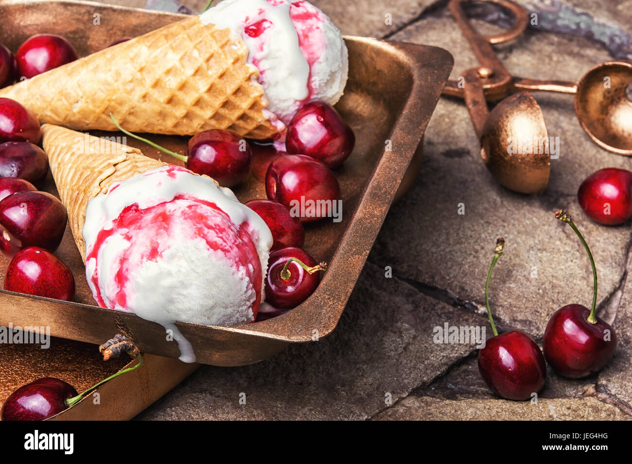 Ice cream in a waffle with cherry jam on a stylish stone background Stock Photo