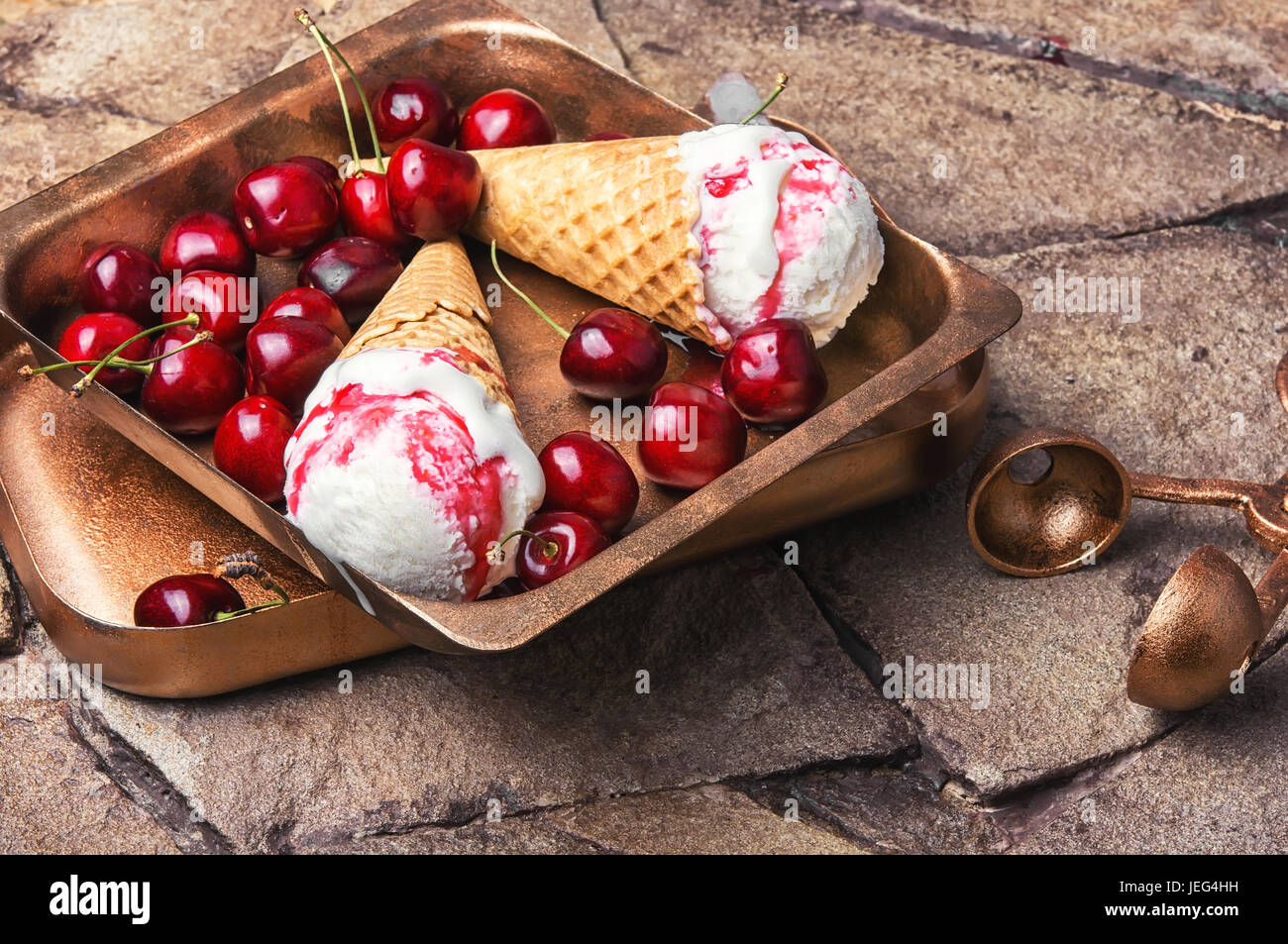 Ice cream in a waffle with cherry jam on a stylish stone background Stock Photo